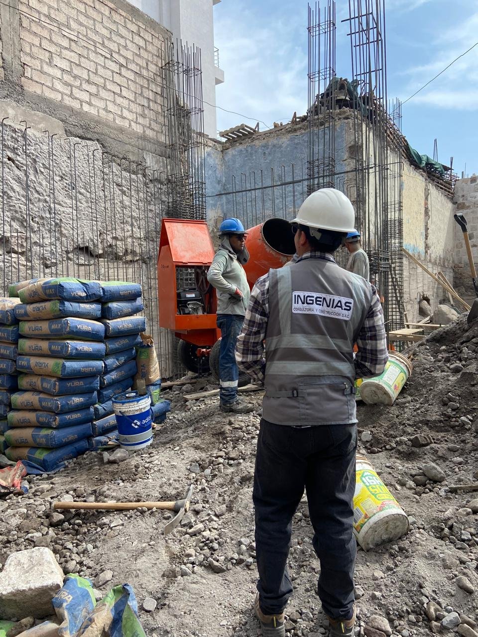 Equipo de INGENIAS en obra civil con mezcladora de concreto